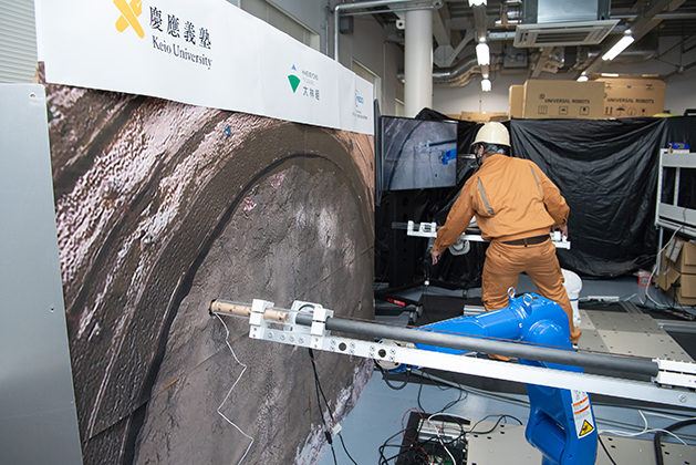 慶應義塾大学ハプティクス研究センター、遠隔で力触覚を再現する技術(リアルハプティクス)を使った山岳トンネル掘削作業の「自動火薬装填システム」をCEATEC 2023でデモ